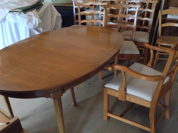 Dining table and chairs, one w/ arms.  2 leaves.  Also three white damask table cloths (w/ napkins)  in various sizes to fit table. And an "every day" green table cloth made to fit.