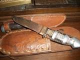 WW II US NAVY knife with a "naughty" leather knife scabbard with a large original Boy Scout knife in background