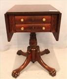 87- Two drawer mahogany drop leaf work stand with claw feet and carved base, 28 in. T, 37 in. W, 18 in. D.