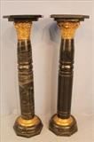 138 - Matching pair of black marble pedestals with gold gilded tops and brass bands at the bottom, 45T