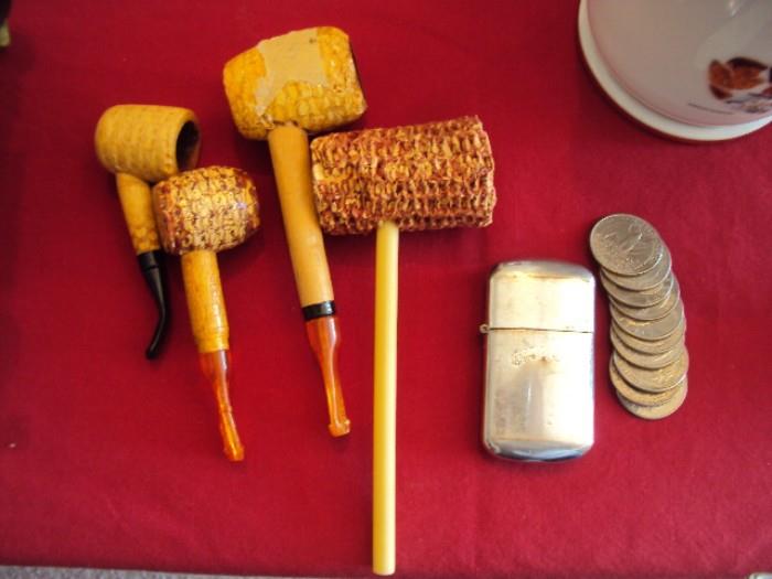 corn cob pipe, Camel cigarette lighter and a stack of quarters