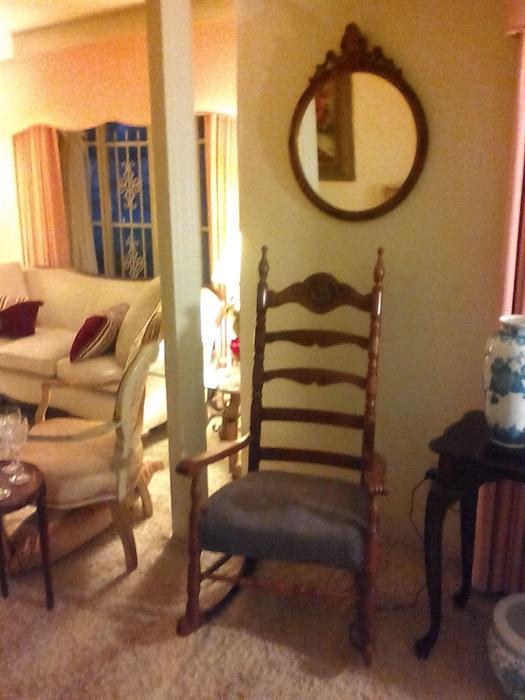 Wonderful antique rocking chair and French mirror hanging above.