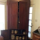 Cabinet # 3 reddish brown, filled with more jug and crocks. This is a corner cabinet