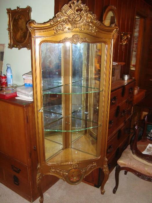 French corner cabinet with curved glass.