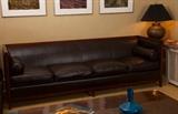 Custom made by Baker, premium brown leather sofa. Goose feather and down pillow stuffing. 2 leather bolster end pillows. Cherry color wood frame, fine contemporary design. 98Lx32W