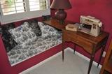 Vintage Singer Sewing Machine in cabinet, decorative pillows, table lamp