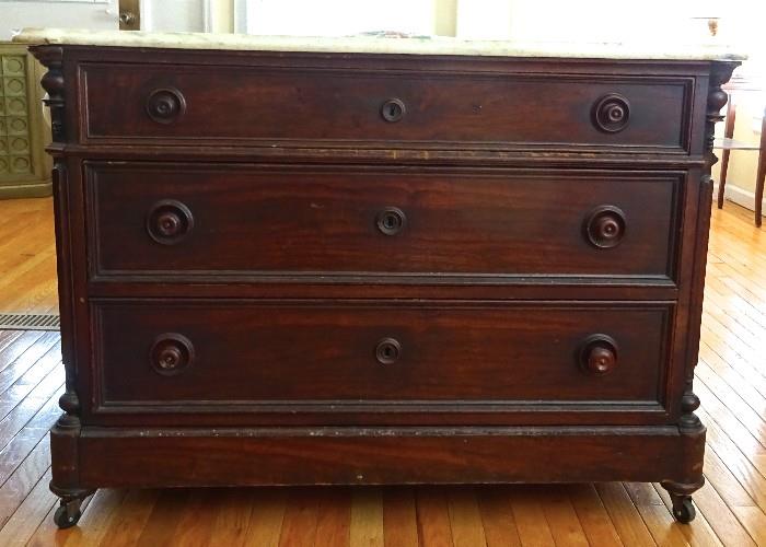 Antique dresser with a unique hidden drawer. Marble top with orginial knobs and castors.  Deep drawers are great for storage. Includes a hidden drawer. 