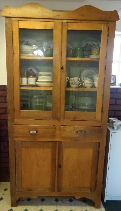 Primitive kitchen hutch that can be easily moved because it is made to fold. Sturdy with two shelves, two drawers and cabinet space. Still has the original hardware.