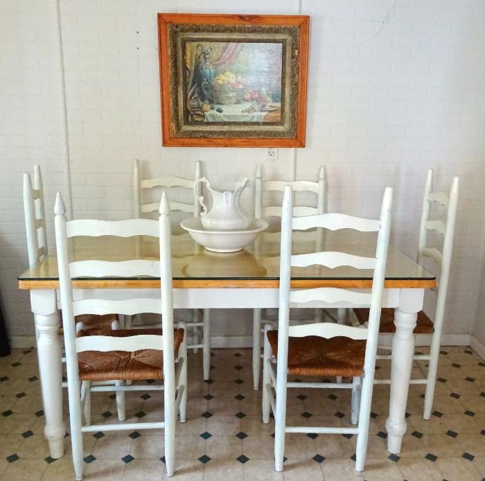 Country kitchen dining set. Table top is covered by custom cut glass protecting the butcher block table top. Set includes six matching ladder back chairs.  This set is like new and ready to move right into your kitchen.