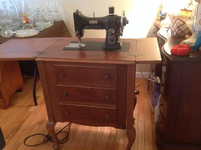 White antique sewing machine in original cabinet with many good sewing notions, material, and much more.