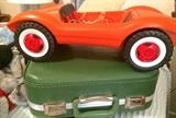 Orange toy car and vintage small suitcase in 70s olive