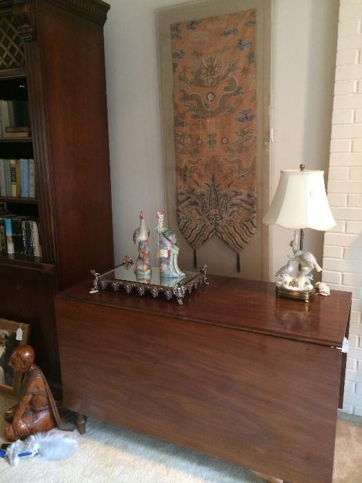 Antique drop leaf table; mirrored tray; bird lamp; framed silk shaw