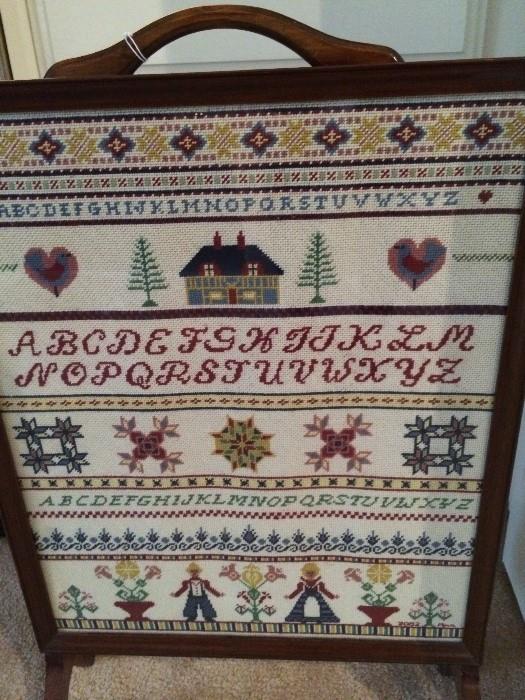    Antique fire screen with cross-stitched sampler
