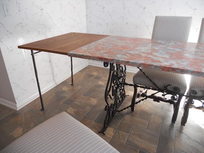 French wrought iron base marble top table with extension set up on one sides (both sides have extensions)!