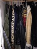 Vintage and new clothing including a leather jacket, faux fur animal print coat, and also an army canvas bag (hanging left)