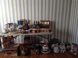 Just a sampling of the kitchen items available for sale including ceramic jards, canister sets, coffee cups, brand new slicer, glass punch set in box, pizza set, various dish sets, etc. 