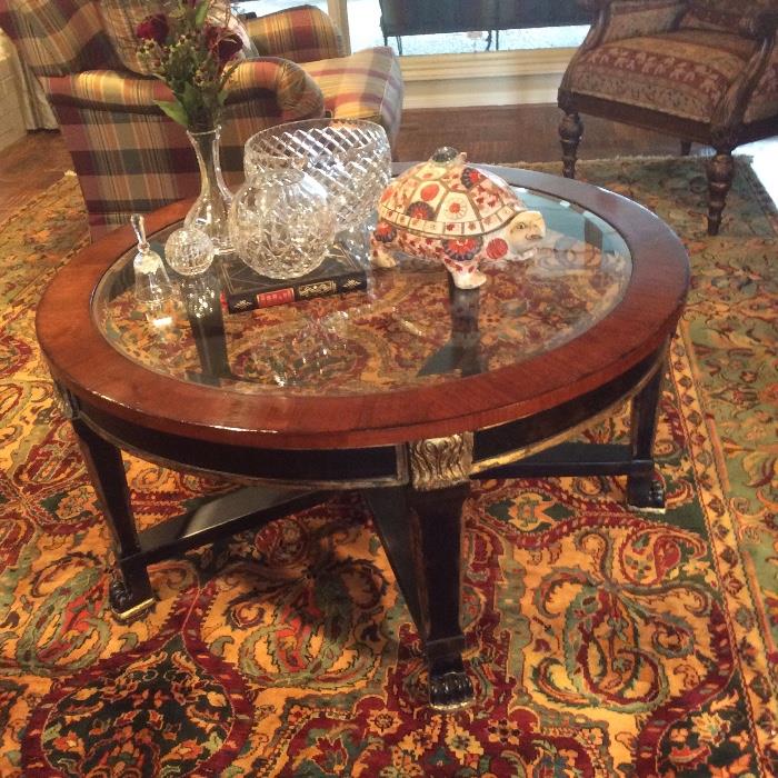 This rug was removed, sorry. We still have this elegant round coffee table with beveled glass. I think the turtle may be a soup tureen, assorted pieces of crystal and glass bowls.