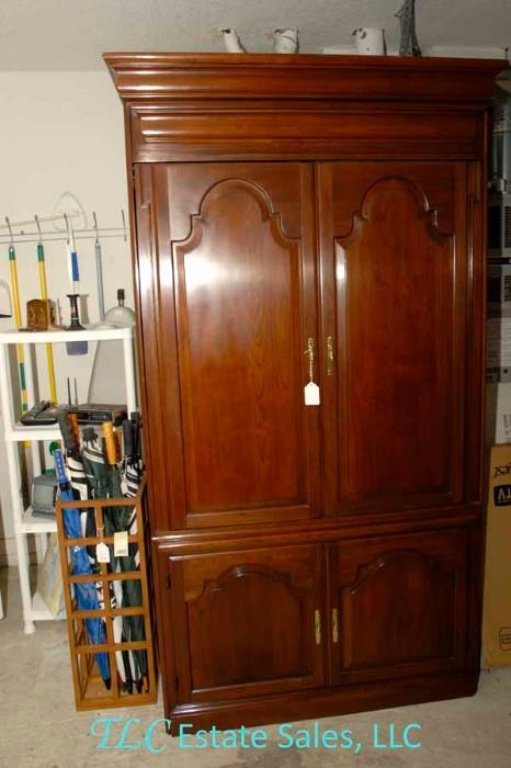 Beautiful Armoire, to the left are many golf umbrellas and a few brooms, etc.