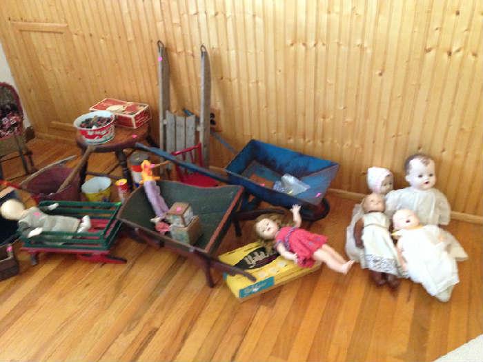 Some of the children's toys including a sleigh,  4 wagons, 2 sleds. a horse cart, 5 dolls, wash basin, pails, doll beds