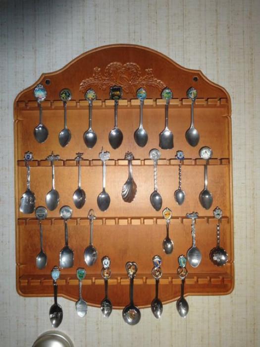 A souvenir spoon rack with numerous spoons.