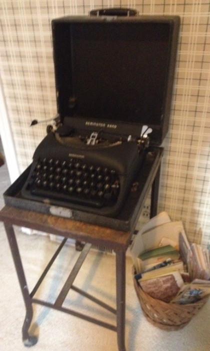 Antique Remington Typewriter on top of an Antique metal Typewriter stand and a basket full of maps