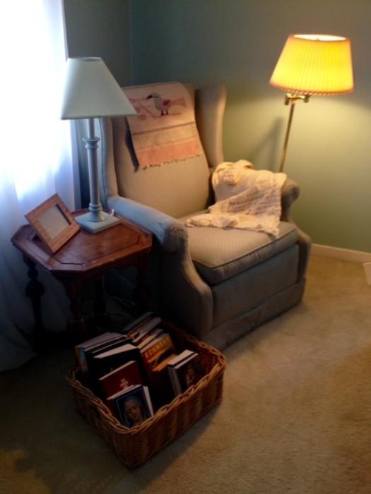 A great Vintage Chair in sage green and small bedside table lamps and a basket full of religious and philosophical reading