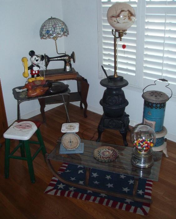 Singer Sewing Machine converted to lamp, Cast Iron Stove converted to lamp, Heater Painted, Santa Stool, Kitchen Scale, Gum Ball Machine, Child's Sled converted to Coffee Table, Americana Rug
