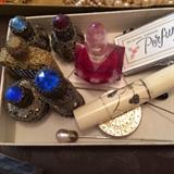 Vintage perfume bottles, filigree, hat pins and white tube container with vanity items
