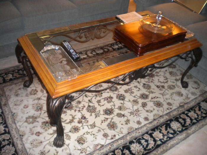 Wrought iron and wood table with glass top and tile/stone inlaid edges.