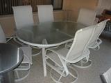 Oval glass-top patio table with 6 spring-rocker chairs.