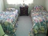 Twin beds and comforter sets. Mattress, box spring sets are in good condition. Also shown is 1 of 2 cherry end tables. 