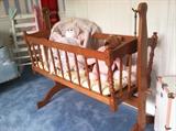 Beautiful baby cradle with mattress and linens...very sweet. Can rock or remain stationary. 