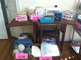 Sewing table with working Singer machine and storage chair, vintage patterns,  fabric, notions, needlepoint, and yarn. 