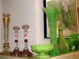 Some of the collection of Green Satin glassware, vases including the lovely Fan Shaped Green Satin Lotus Flower vase, candlestick holders, decanter;  Also shown are matching pair of accent crystal glass candlestick holders, and tall  vase with gold  tone accents; Large framed poster in the background is also available.  