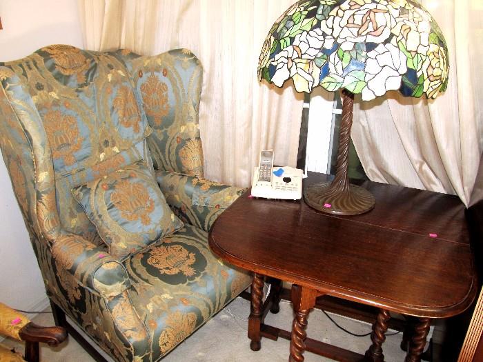 Queen Anne Style Wing Back (High Back) Chair with rolled arms,  and elegant blue / gold satin brocade upholstery;  Antique Gate Leg  Table...beautiful Tiger Oak, with nicely carved twist style legs; The reproduction Tiffany Style Lamp with metal base is also available