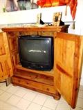 Pine Entertainment Center with Double doors with metal hinges accents and ring pulls,  drawer storage, Bun Feet;  Also shown is a Sharp Color TV with VCR.
