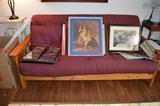 Wooden futon, art work, tall light colored table/plant stand