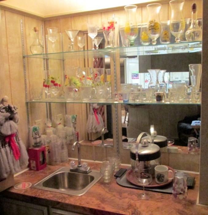 Home bar with ice bucket, jiggers, bitter's bottle and various type drink glasses and goblets.