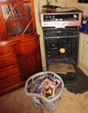 HIGH END AMPLIFIER RECEIVER SITTING ATOP A COMMERCIAL GRADE  ENTERTAINMENT CENTER---BIN OF MUSIC CDS--