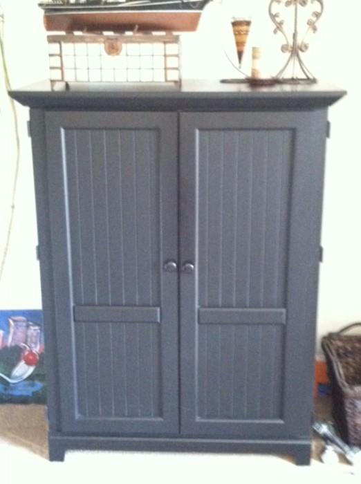 Black armoire holds 36" TV and room for other electronics.  Perfect for a other types of storage.