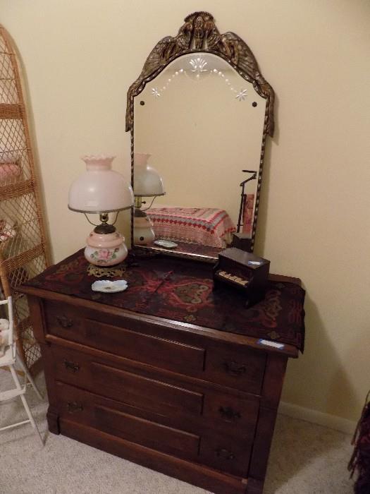 antique chest of drawers shown with antique mirror and lamp....see the tiny childs antique piano too