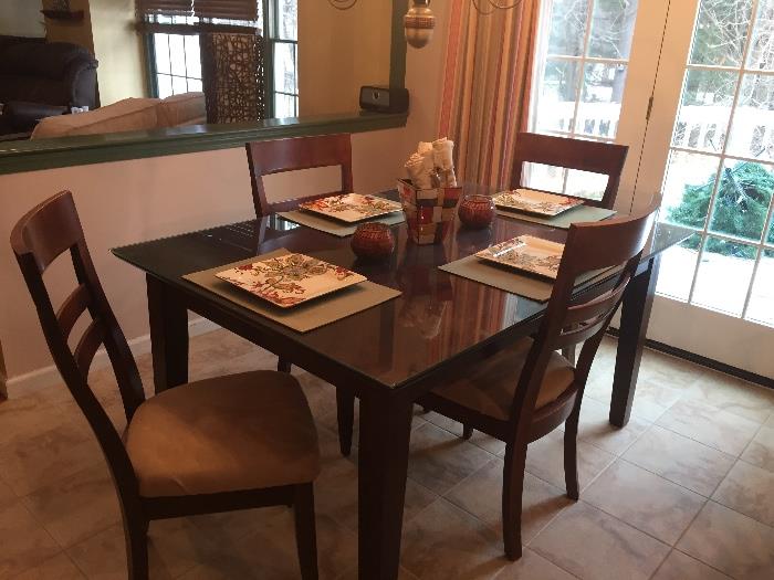 Dining room/kitchen set (leaf included, not shown), with 4 matching chairs (seats covered in beige faux suede) and glass protective top