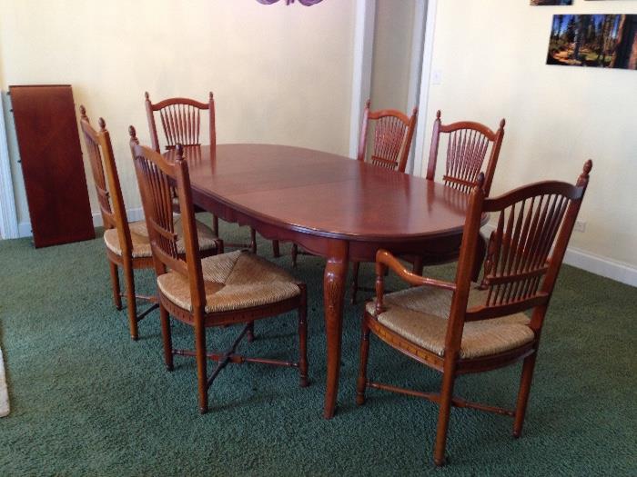Wood Dining room set with inlaid diamond pattern.  Table is 64" long and 42" wide without leaves. Includes two 15" wide leaves extending total length to 94".  Chairs have wheat pattern on back and rattan/wicker seats.  Manufacturer unknown.  Minor surface scratching - otherwise in excellent condition.