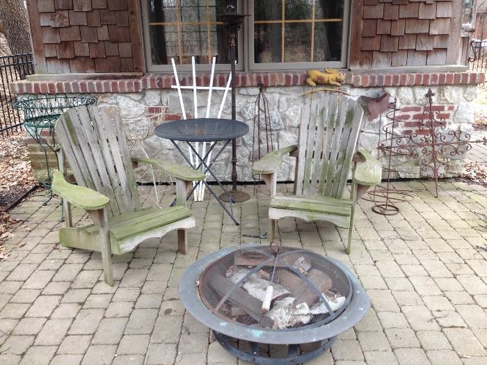 Wood adirondack chairs, fire pit, torch, and various metal lawn ornaments.