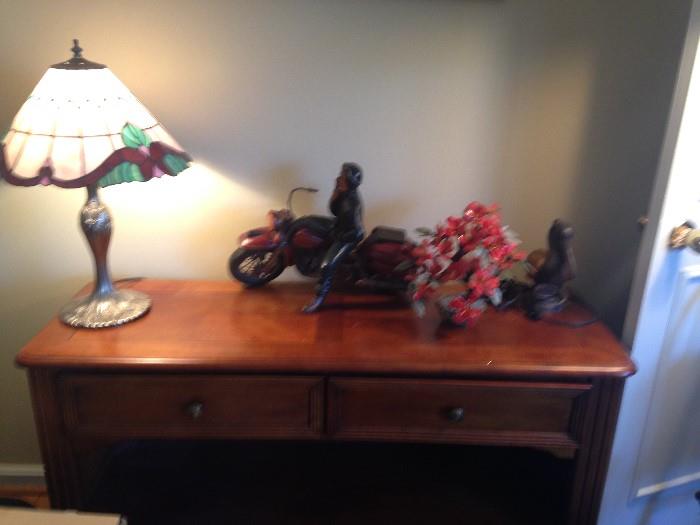 Console table, lamps and sculpture.