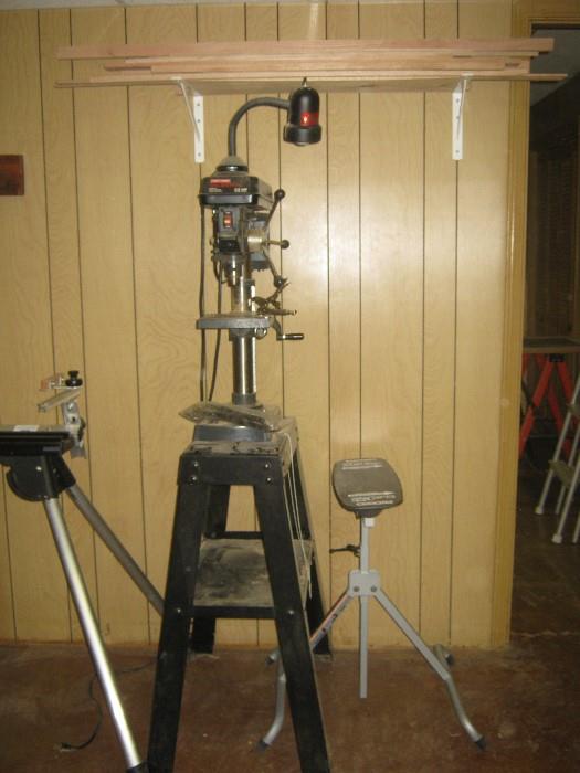 Craftsman 10" drill press w/ 1.2hp motor, 1.2" chuck, on stand w/delta work light, next to press is Rigid flip top material holder