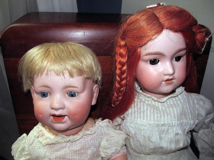 PAIR OF ANTIQUE DOLLS, DISPLAYED ON AN ANTIQUE CHILD SIZE SCHOOL DESK