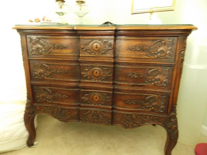 This is one of the nicest hand carved antique dressers I have ever seen. There is one key that is used to pull the drawers open. There are no pulls in the design.  There is a custom cut glass top.