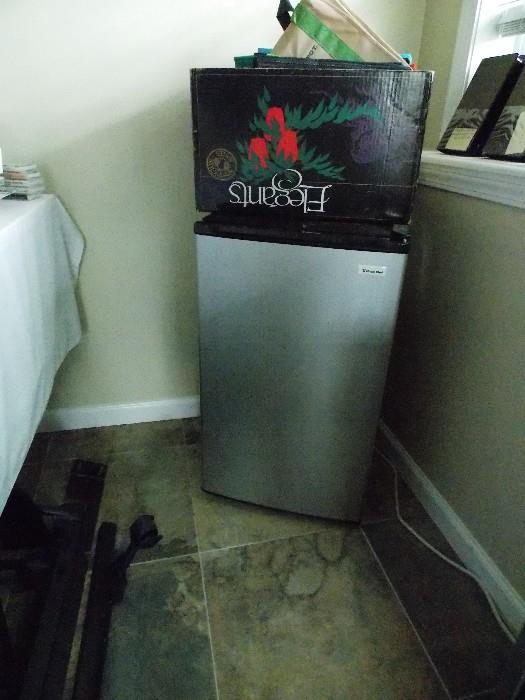Small refrigerator. Box on top is full of fabric grocery bags. Some are very very nice.