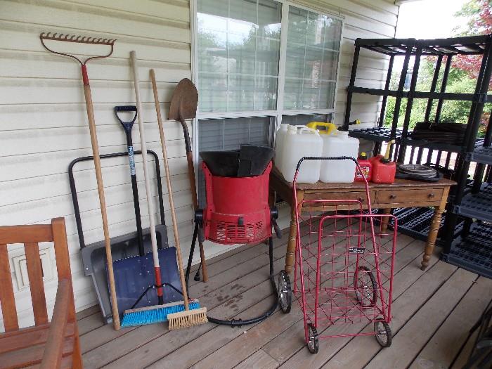 Shovels, rakes, brooms, leaf mulcher, plastic jugs, gas cans and red cart